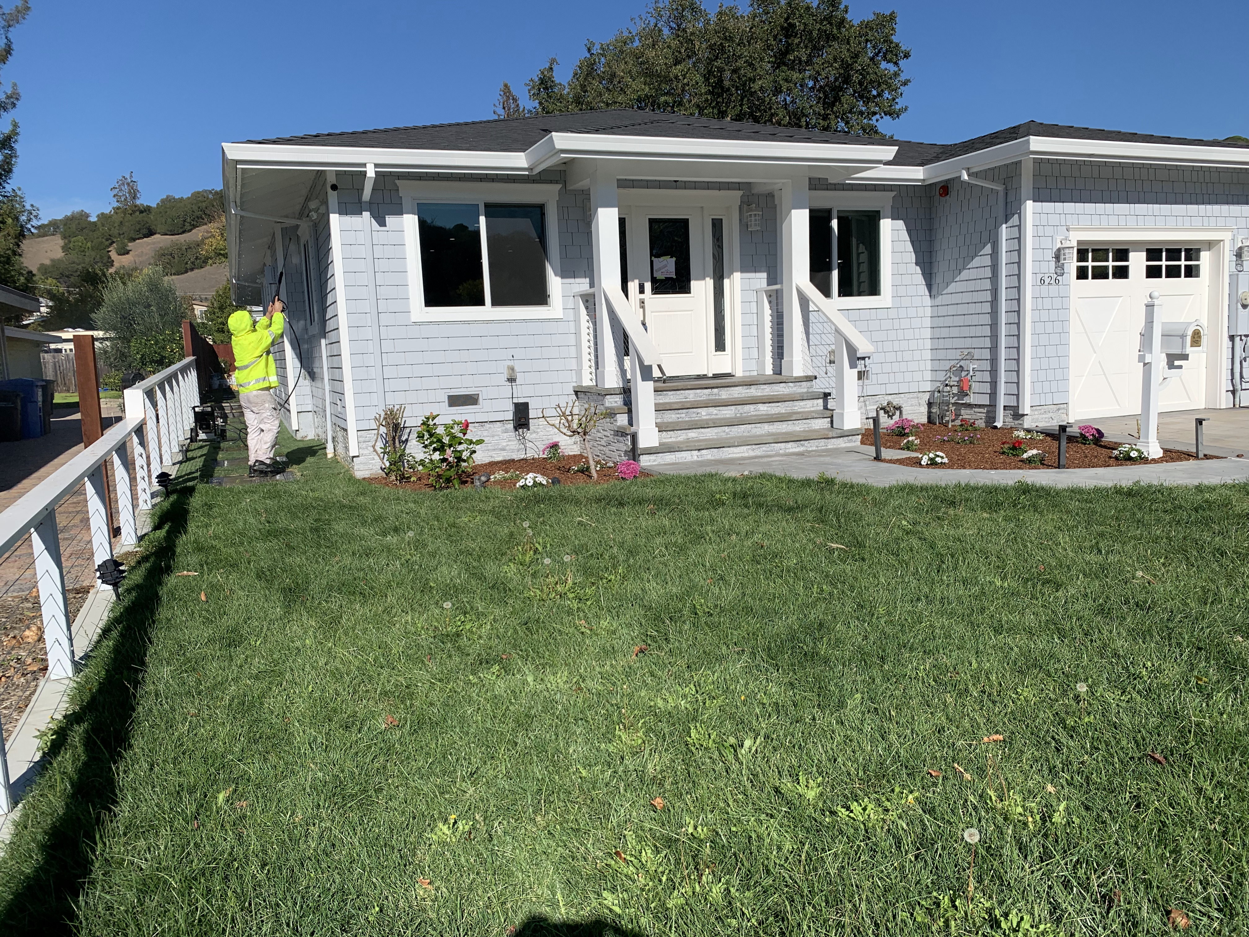 White craftsman home with front porch and landscaping